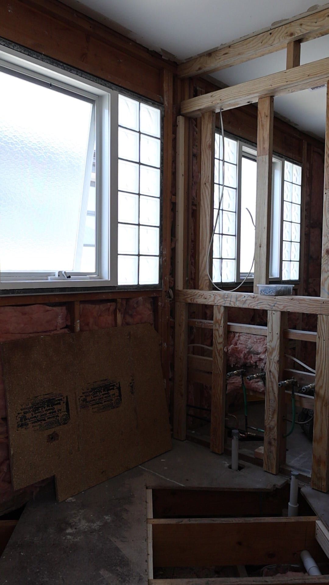 A bathroom reframed back to studs, with new plumbing rough-in and the subfloor opened up