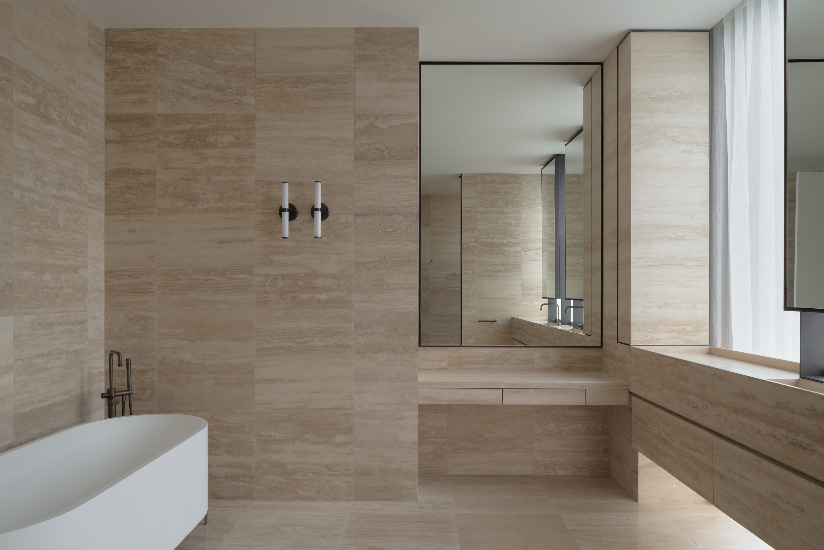 The bath within the full-height travertine room at Cranston House