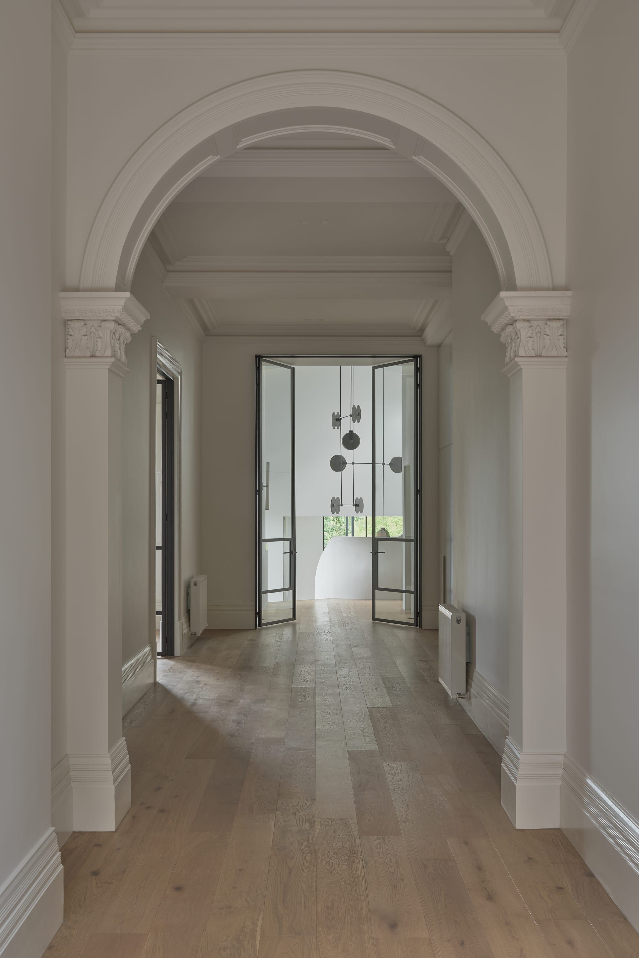 Steel-framed glazed doors set within restored masonry arches at Cranston House