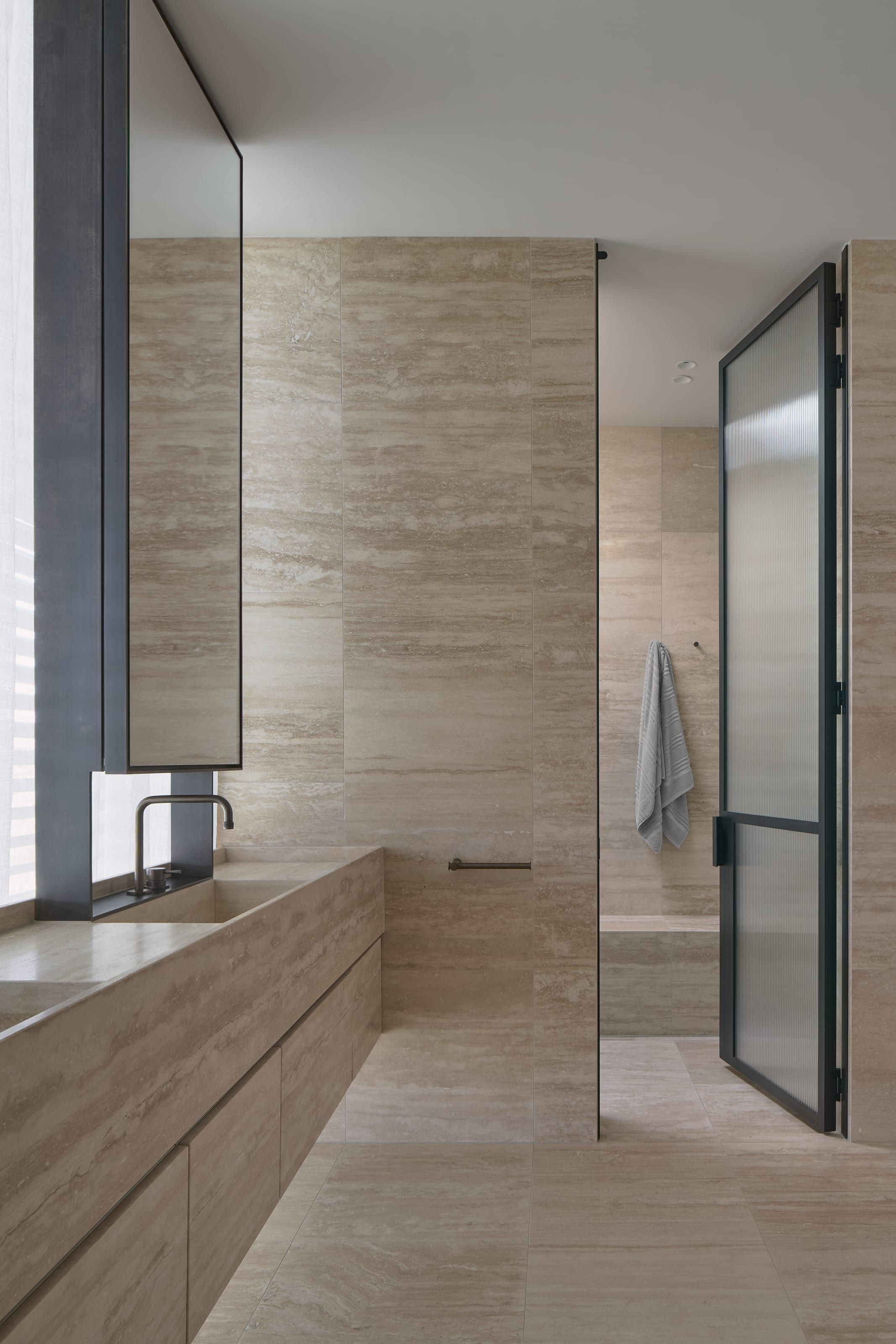 The ensuite vanity in travertine