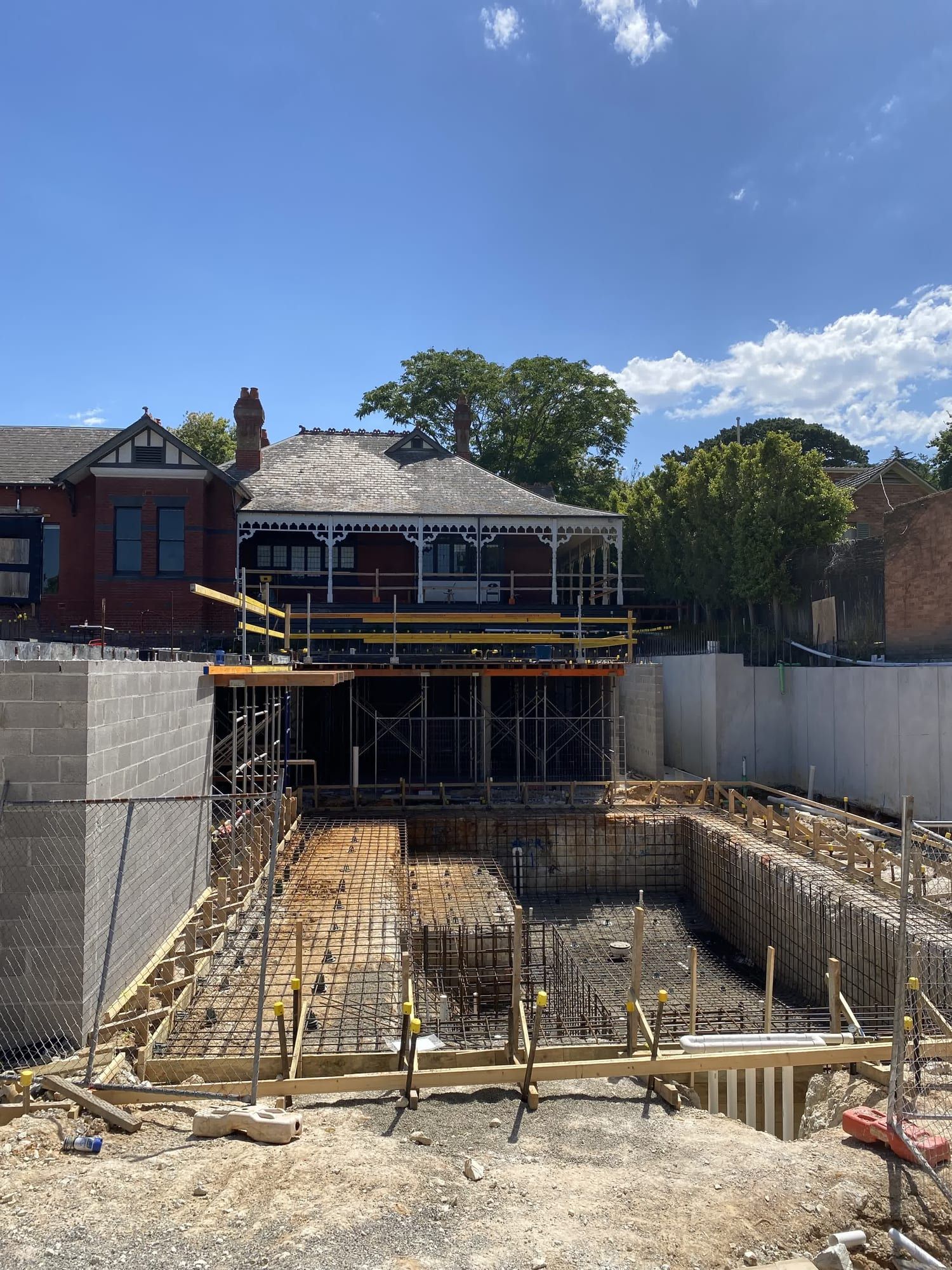 The basement excavation during construction, with the retained heritage house behind