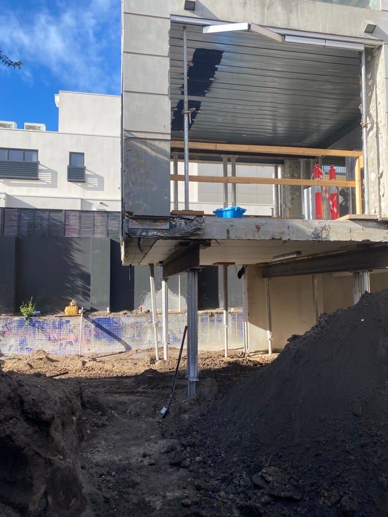 Steel props carrying the floor slab over the open basement