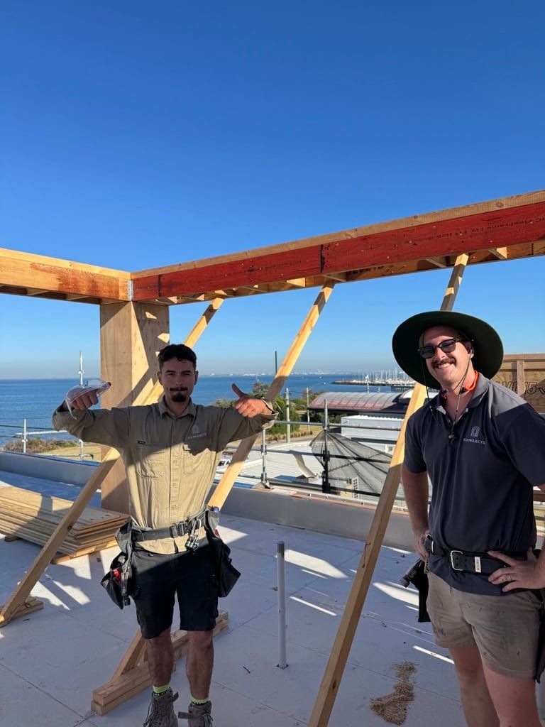 Siji carpenters on the roof structure of the Brighton site on a clear day
