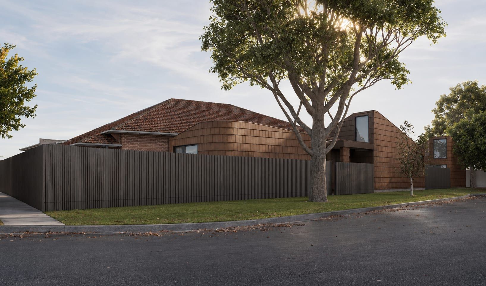The extension at dusk, seen across the corner behind the timber batten fence